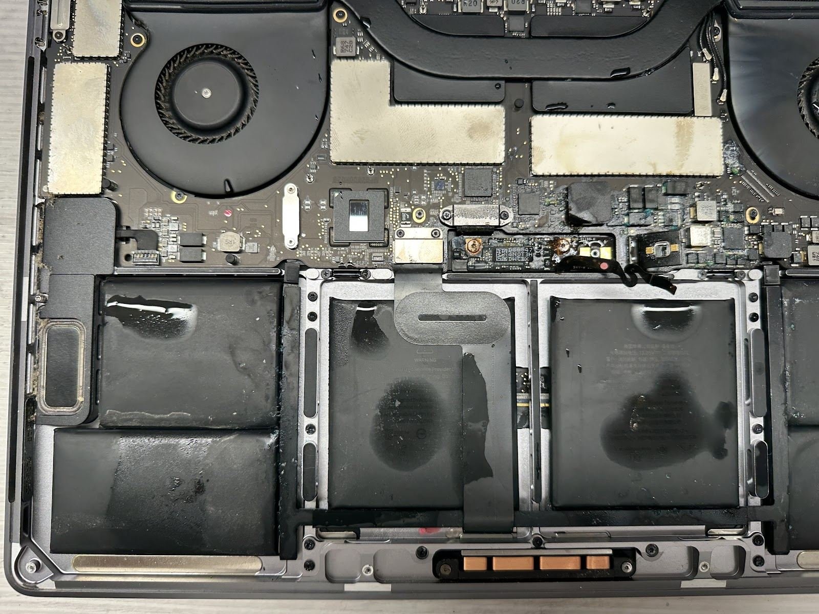 MacBook Pro mojado con restos de líquido sobre la placa
