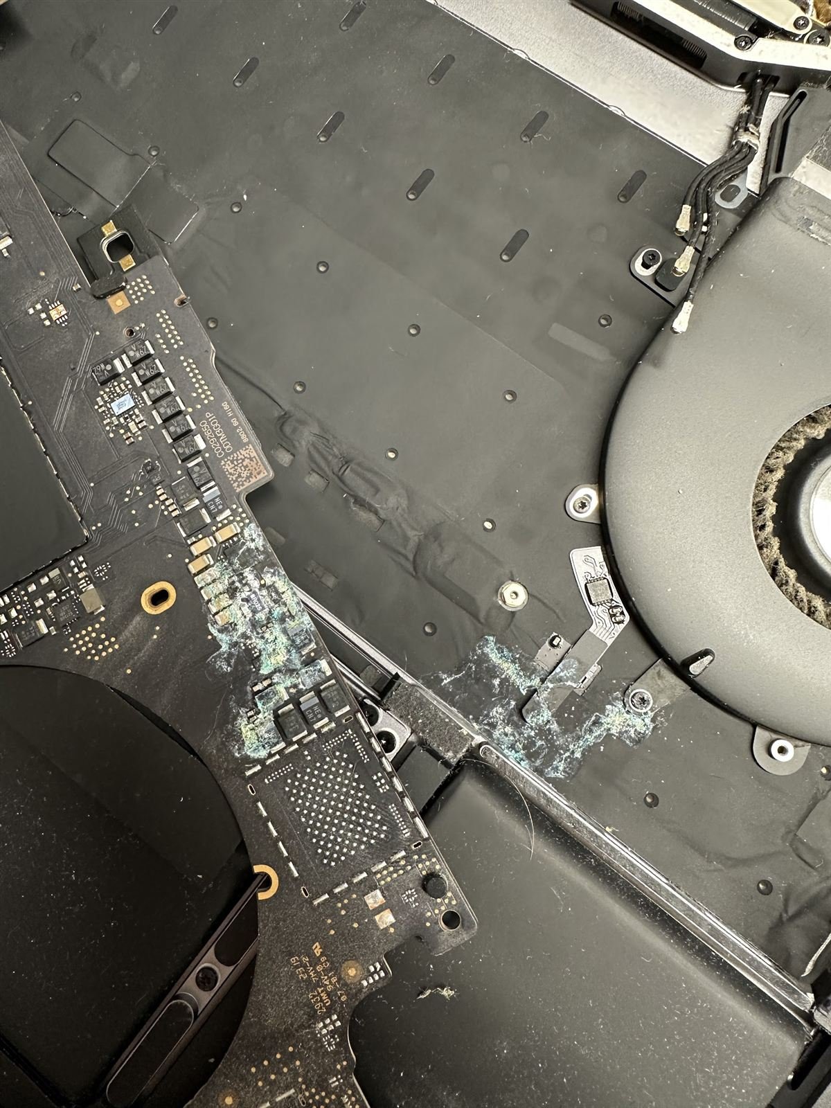 Corrosión en la placa base de un MacBook mojado reparado en Reus